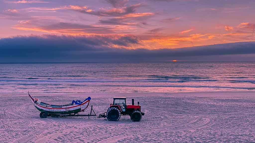 costa-de-lavos-bei-abend-mit-boot-und-traktor Abendstimmung in Costa de Lavos mit Meer im Hintergrund und Traktor mit angehängtem Fischerboot im Vordergrund