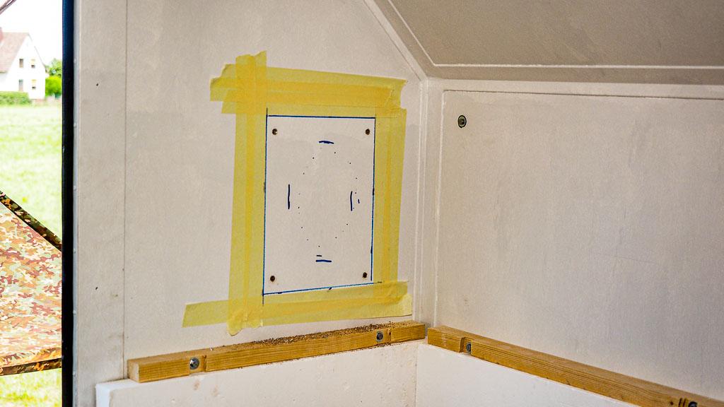 Mit Klebeband markierter Wanddurchbruch für Schornsteindurchführung